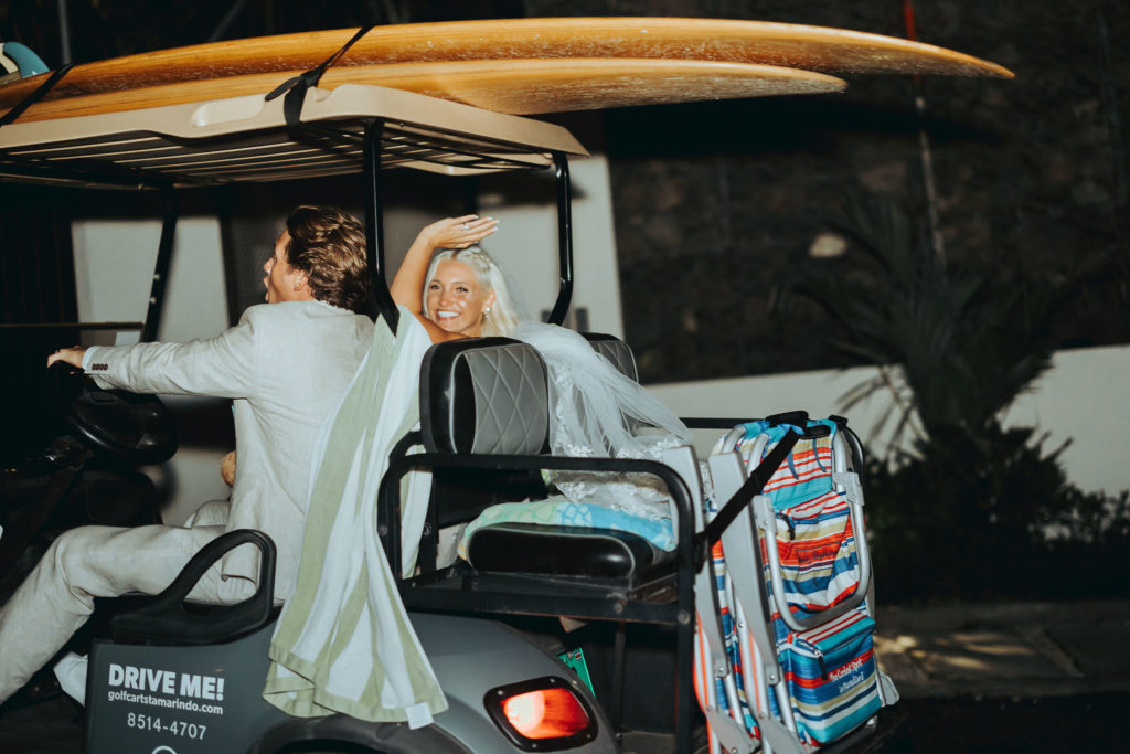 bride and groom riding away on golf cart
