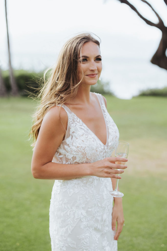 bride with a glass of champagne in maui hawaii reception
