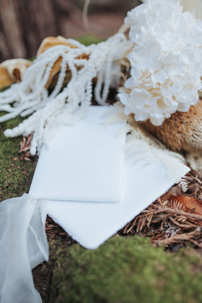 vow books with bridal bouquet