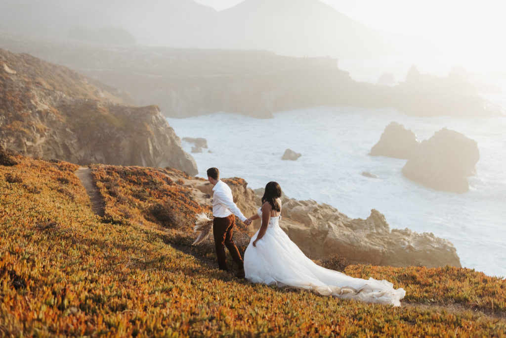 bride and groom walking on the coast in big sur