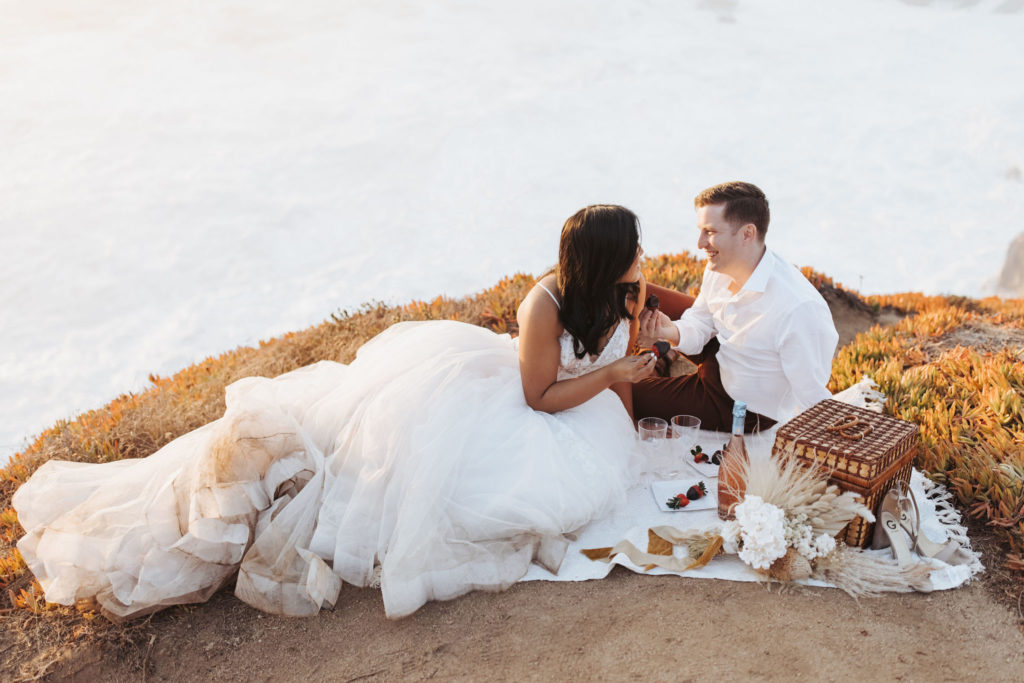 bride and groom eating chocolate strawberries in big sur elopement picnic