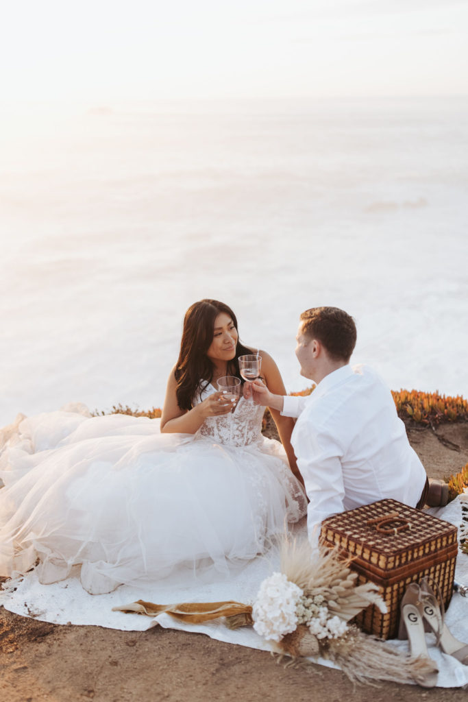bride and groom drinking champagne at big sur elopement picnic