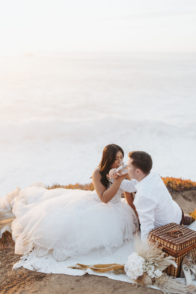 bride and groom drinking champagne at big sur elopement picnic