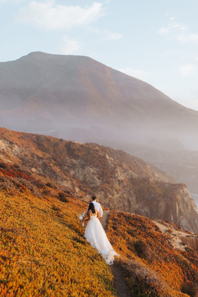 bride and groom walking on the coast in big sur