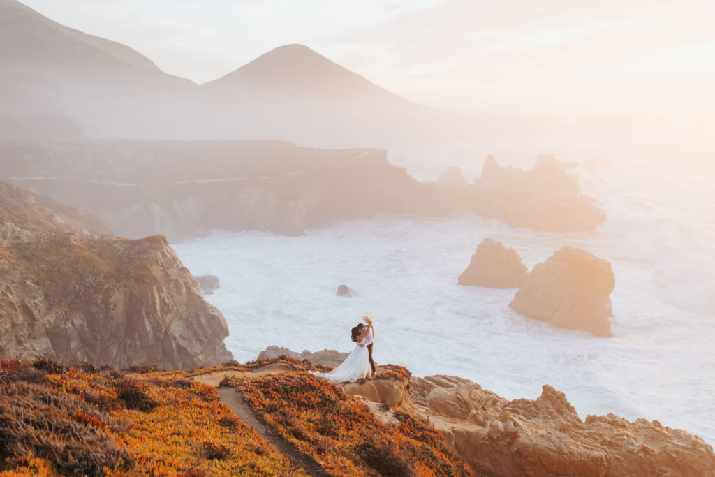 bride and groom portraits in big sur with waves crashing behind them