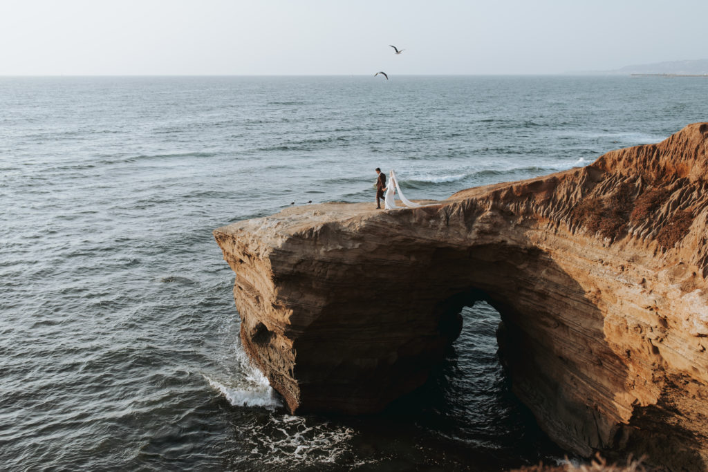 bride and groom portraits on cliff in san diego