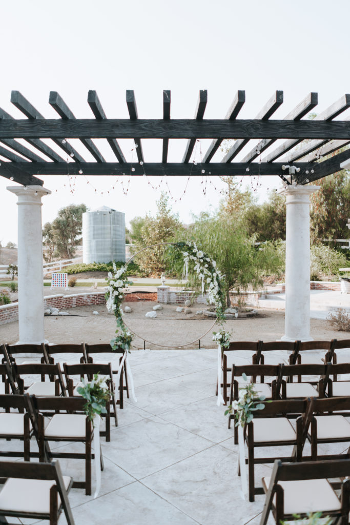 temecula wedding ceremony with string lights and floral arch