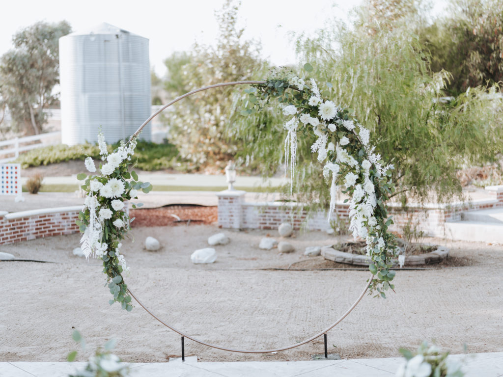 temecula wedding ceremony with string lights and floral arch