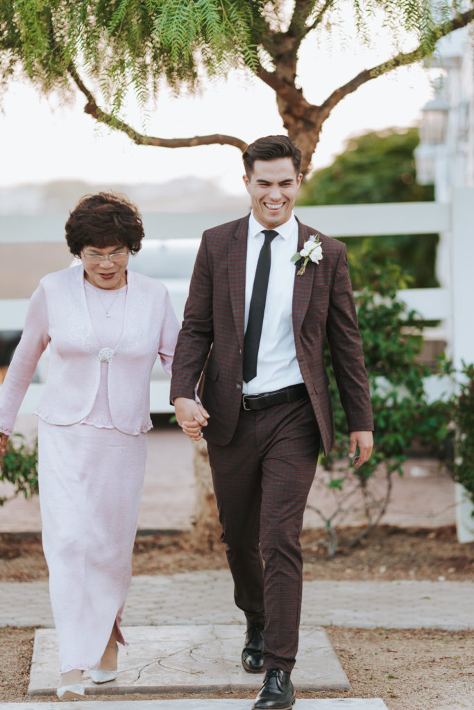 groom walking with mother at temecula wedding