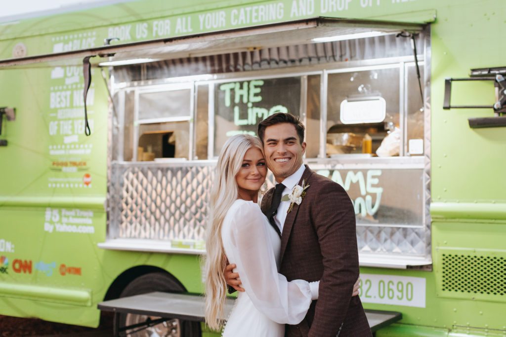 bride and groom in front of food truck at temecula wedding reception