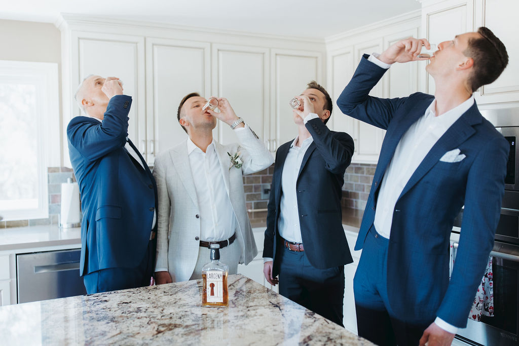groom and groomsmen drinking a shot of whisky