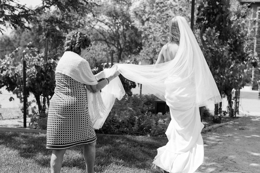 bride walking with mother holding veil