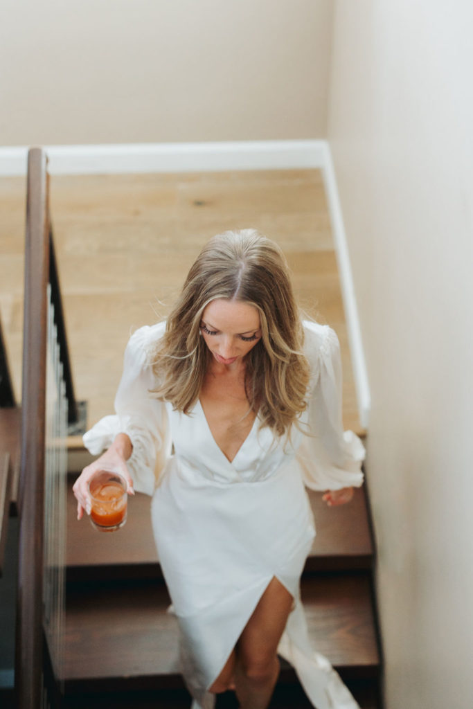 bride walking down stairs with cocktail