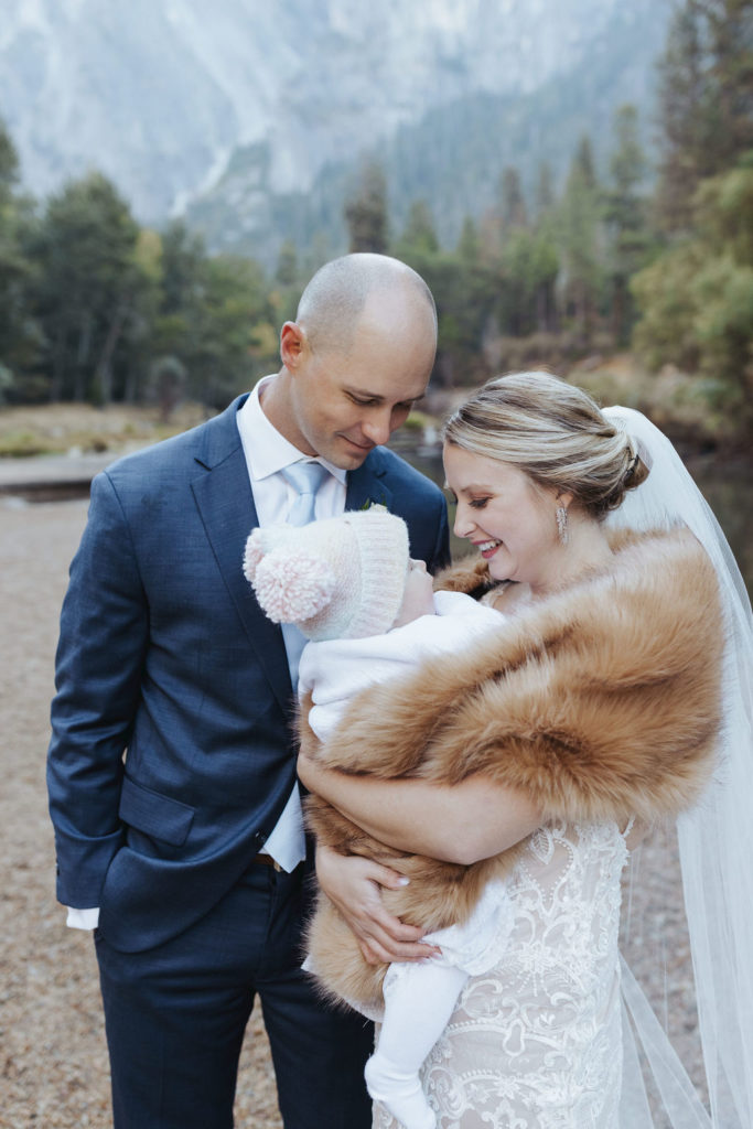 bride and groom with baby at cathedral beach wedding