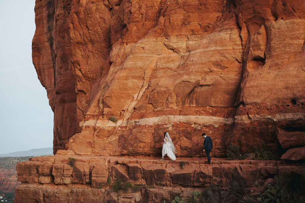 bride and groom hiking in cathedral rock