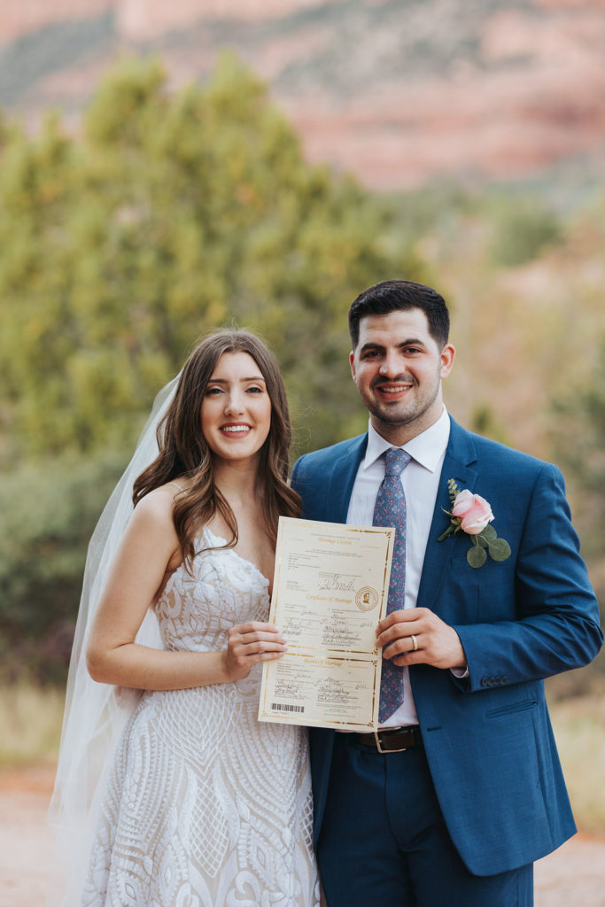 bride and groom holding marriage certificate at arizona elopement