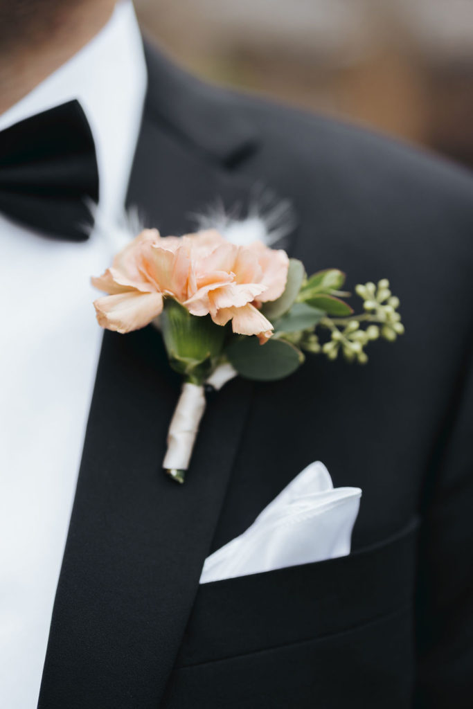 groom's boutonniere on black suit