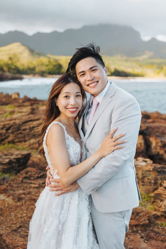 bride and groom portraits on rocky coast in kauai hawaii