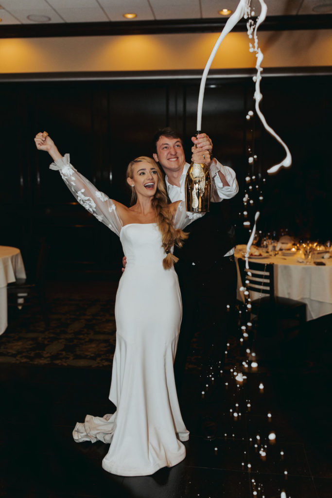 bride and groom popping champagne at las vegas reception