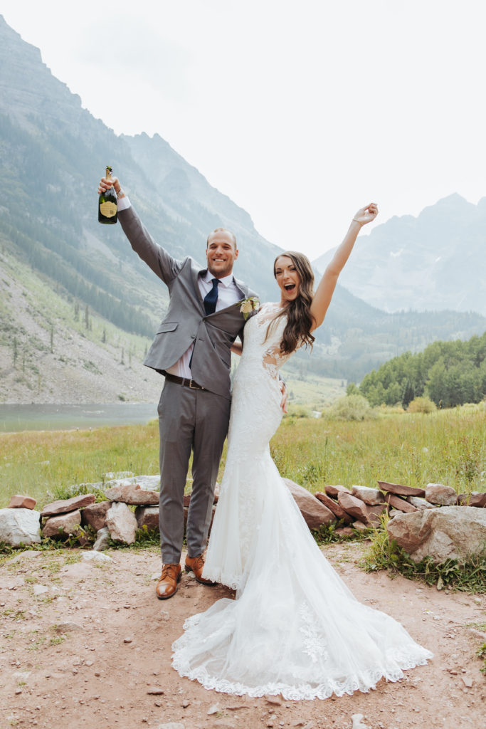 bride and groom popping champagne at maroon bells wedding