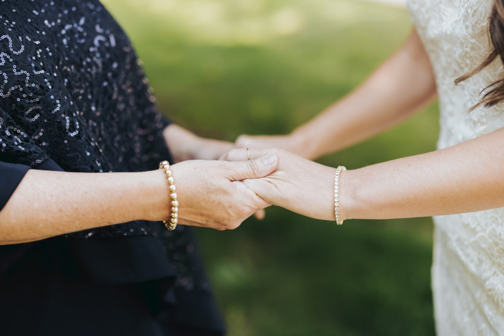 bride and mother holding hands at colorado wedding