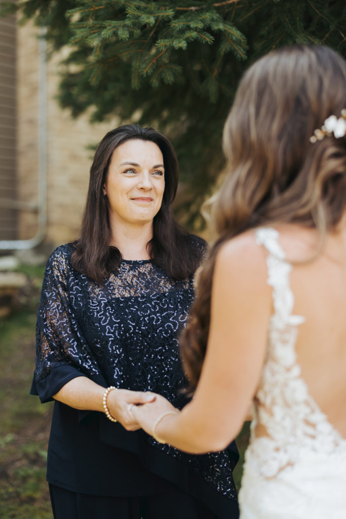 bride and mother holding hands at colorado wedding