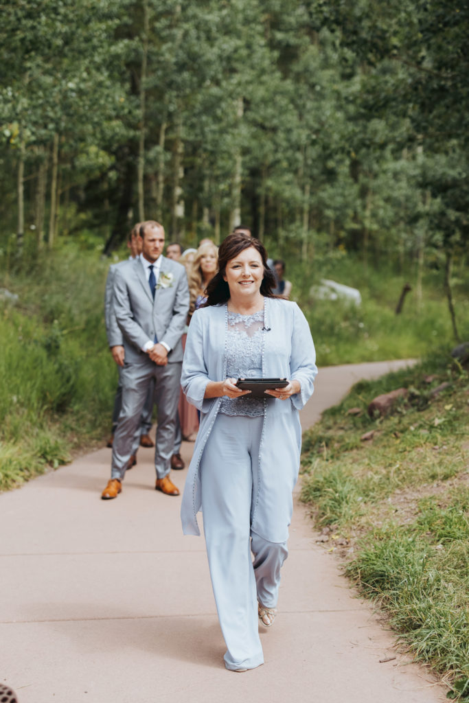 officiant walking with bridal party for maroon bells wedding