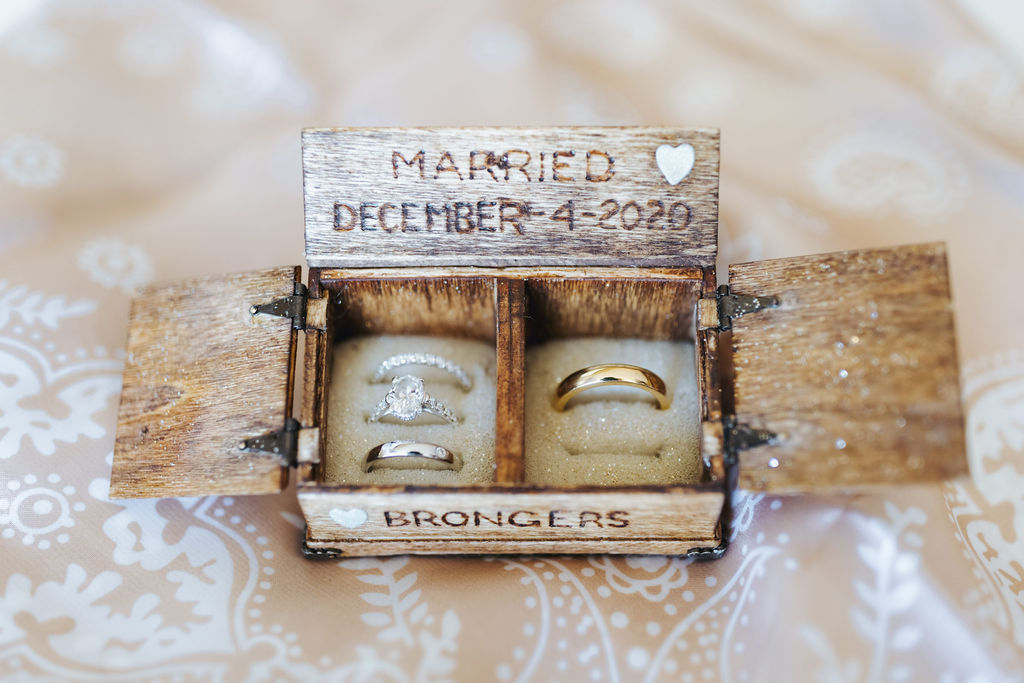 wedding rings in wooden ring box with anniversary carved in the top