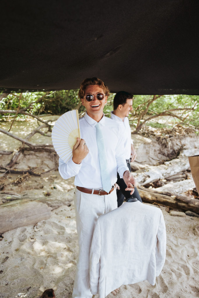 groom holding fan and jacket at costa rica wedding