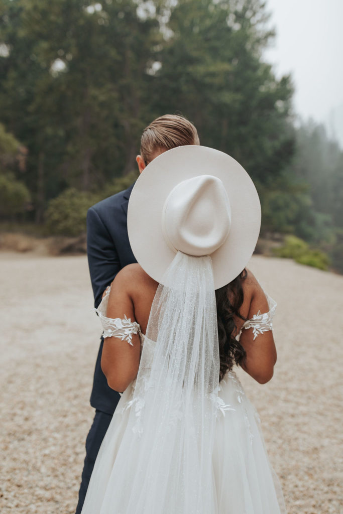 bride wearing hat with groom in yosemite elopement