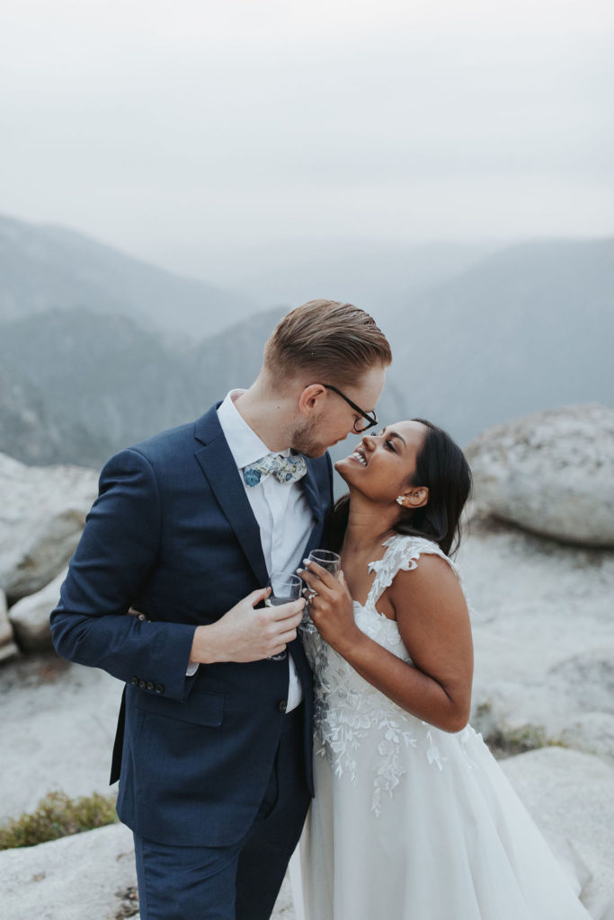 bride and groom in yosemite elopement portraits drinking champagne
