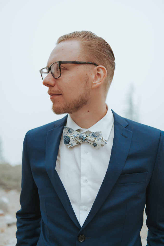 groom portrait with floral bowtie and navy suit