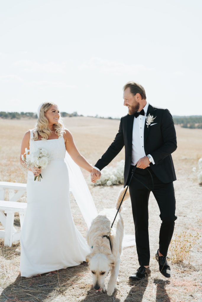 bride and groom with dog on leash in utah wedding