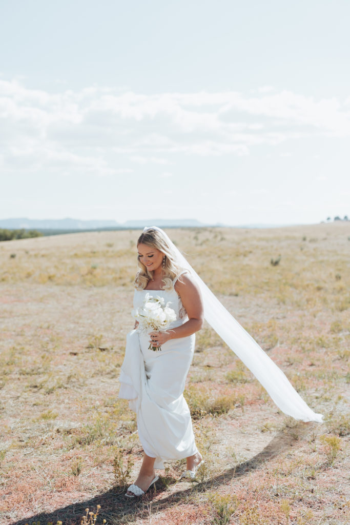 bride walking in field in utah