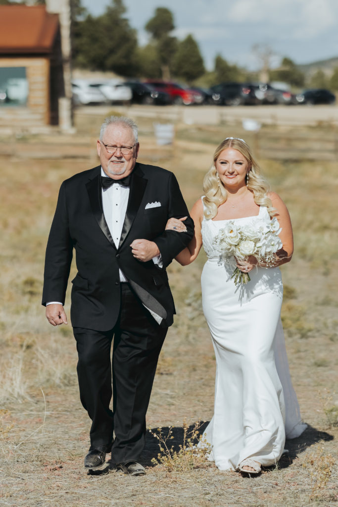 bride walking with father in utah wedding ceremony