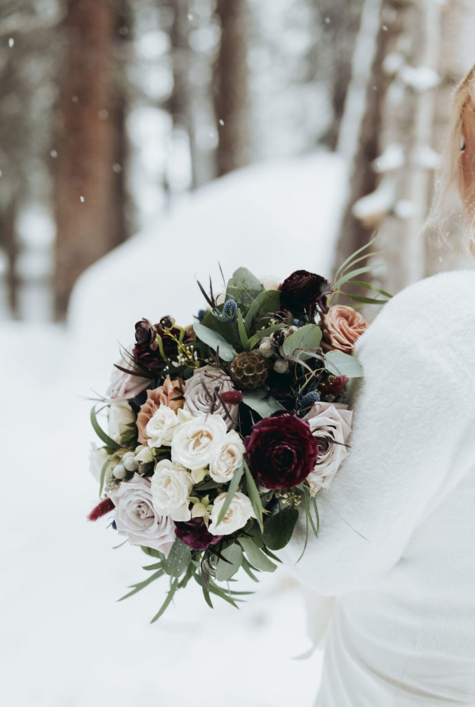 bridal bouquet with pink and white flowers in the snow