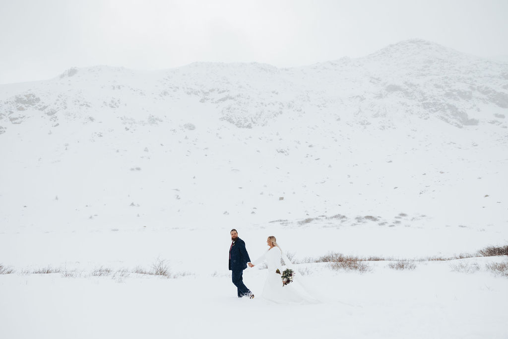 bride and groom portraits walking in the snow