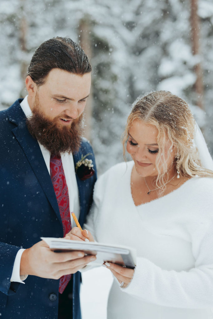 bride and groom signing marriage license snowy mountain elopement