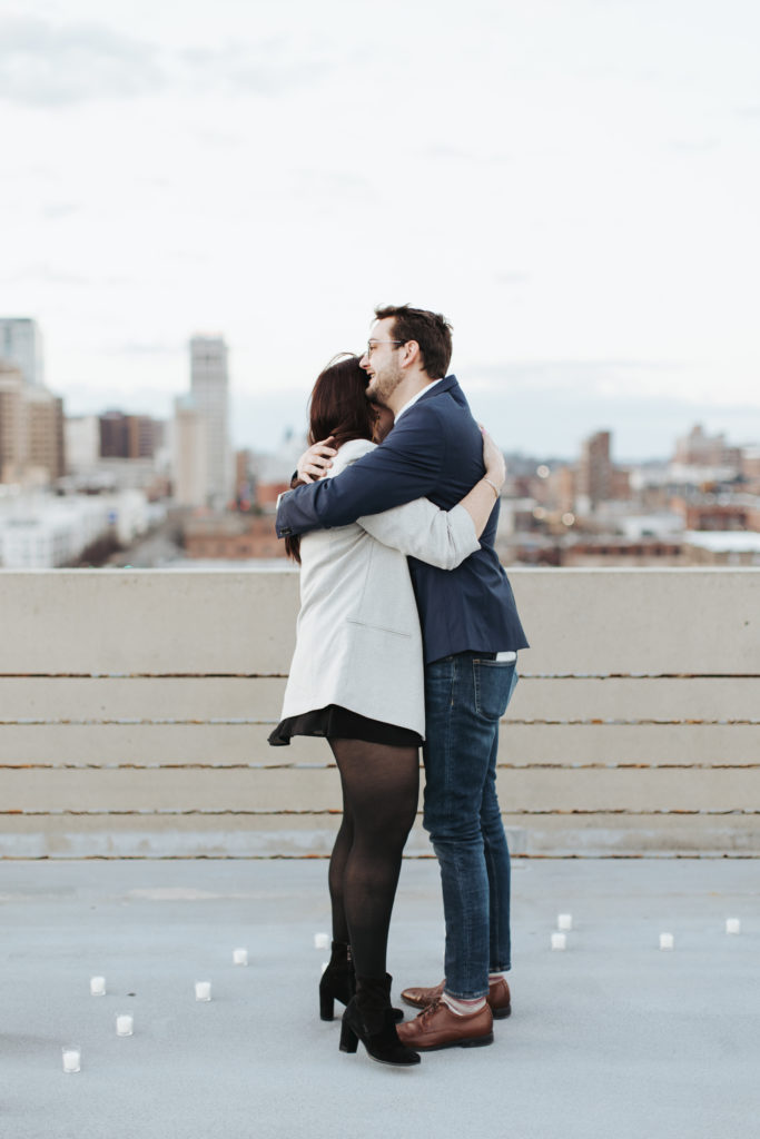 engaged couple hugging on birmingham rooftop