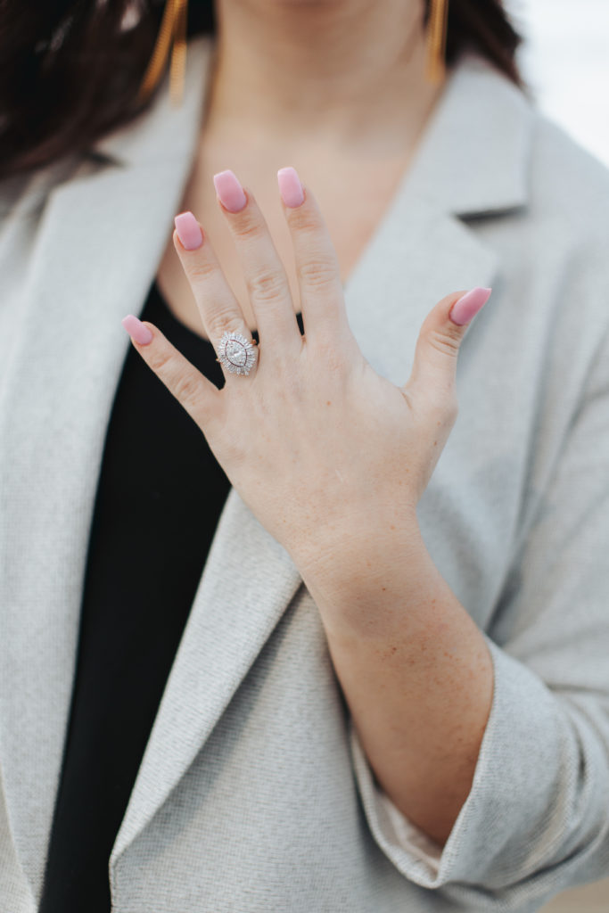 woman with pink nails showing engagement ring at surprise proposal