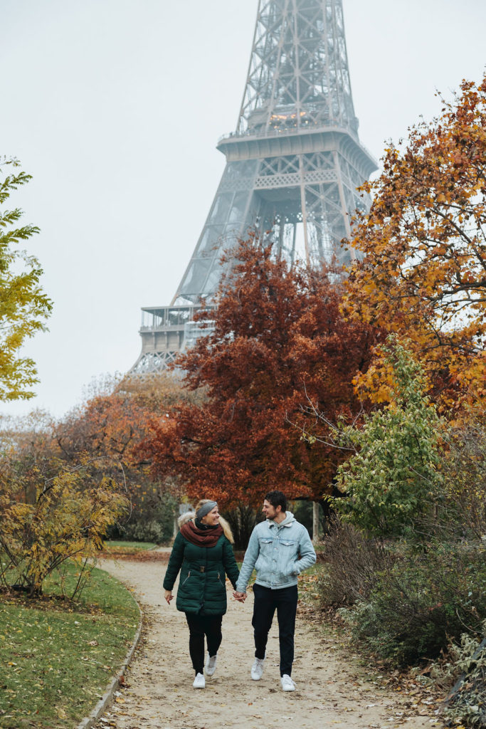 couple walking in front of eiffel tower