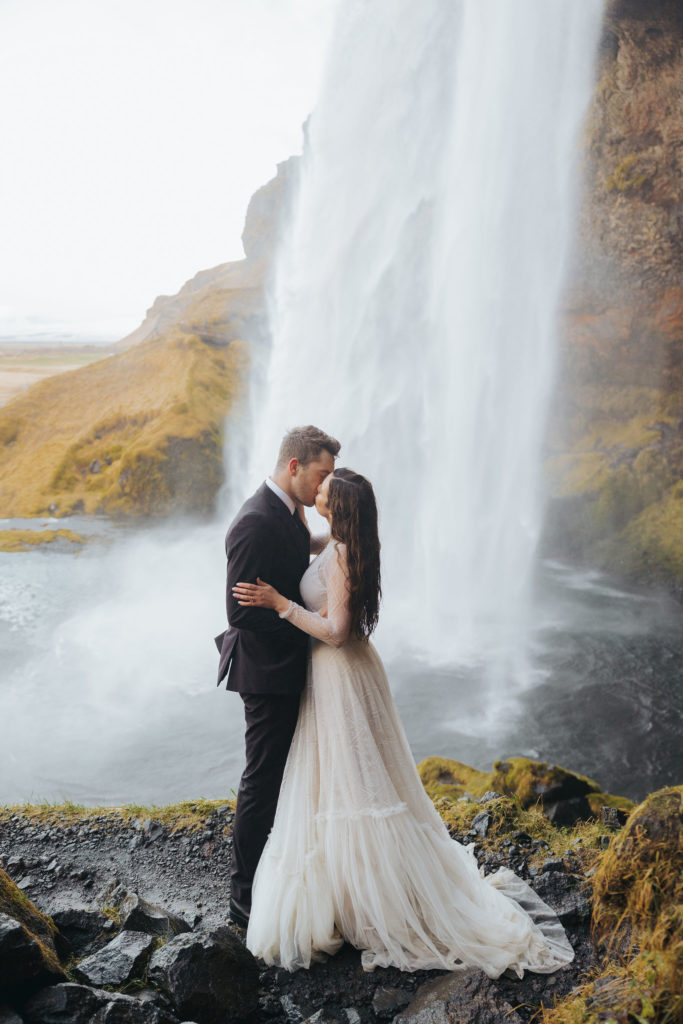 bride and groom elopement under waterfall in iceland