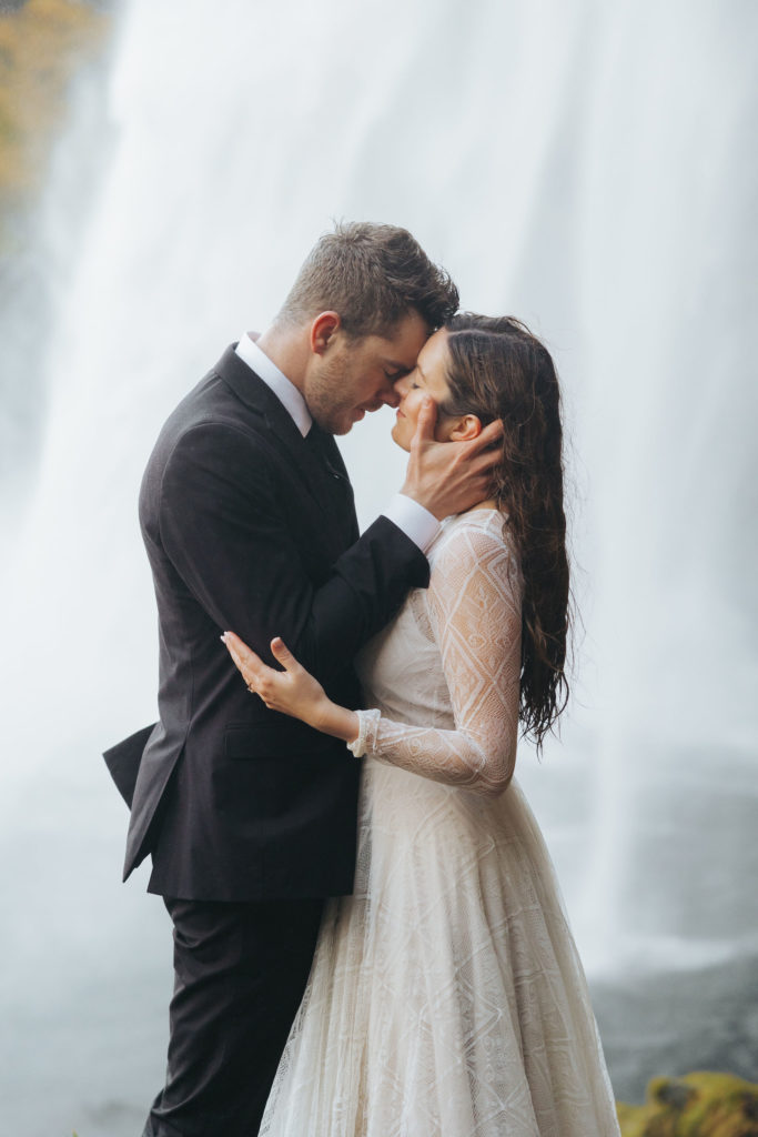 bride and groom elopement portraits under waterfall in iceland
