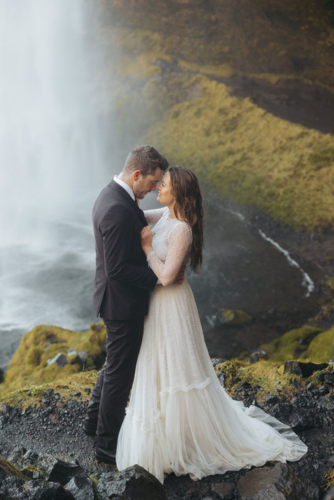 bride and groom elopement portraits under waterfall in iceland