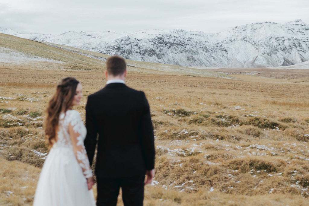 wedding couple during elopement day on snowy mountains in iceland