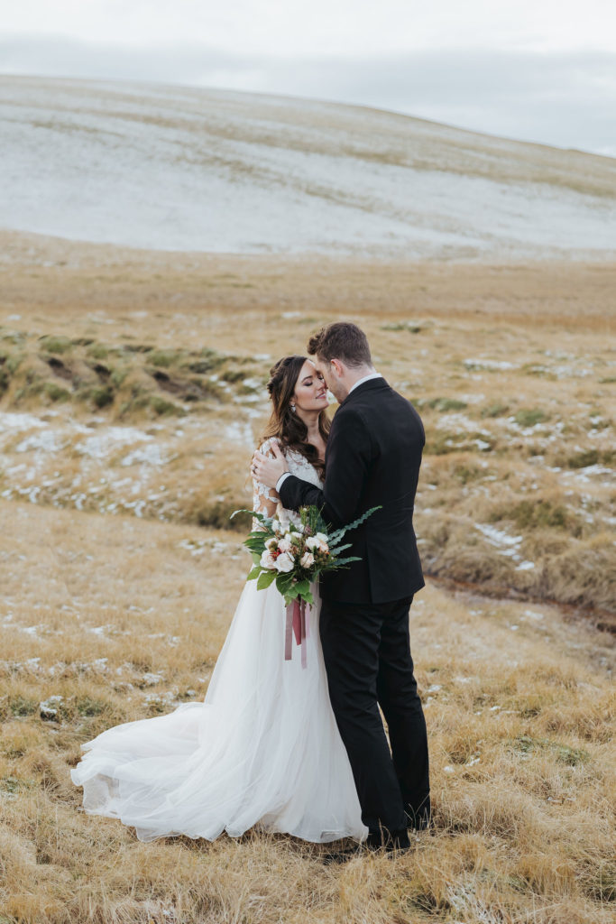 wedding couple kissing during elopement day on snowy mountains in iceland