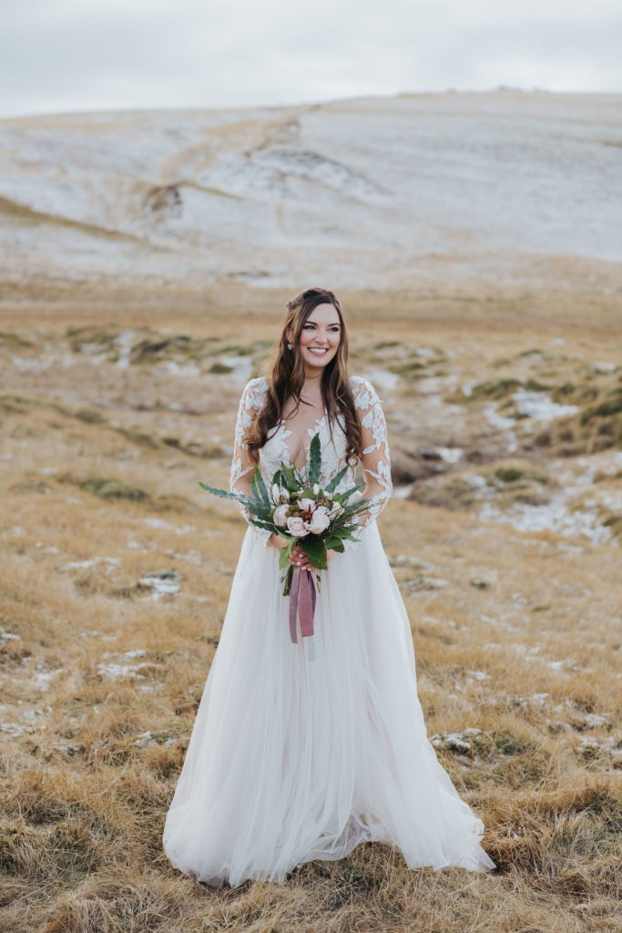 bride portrait with pink bouquet on snowy mountains in iceland