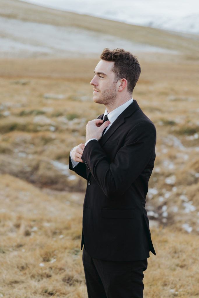 groom portrait in black suit and black tie in iceland