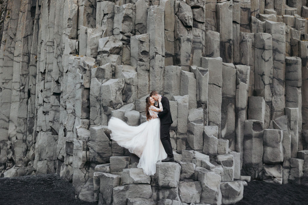 bride and groom on Reynisfjara Iceland rocks