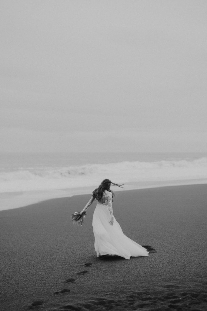 bride walking on black sand beach iceland